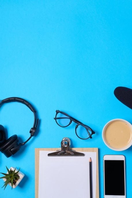 music-podcast-background-with-headphones-microphone-coffee-blank-blue-table-flat-lay-top-view-flat-lay